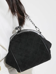 Classic black quilted shell bag with vintage kiss-lock closure and elegant chain strap