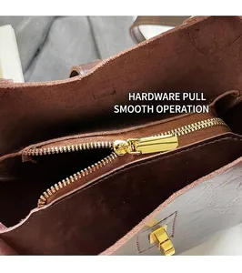 Detailed macro view of the gold-tone metal zipper and textured brown leather on handbag