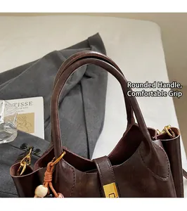 Close-up of dark brown vintage leather handbag with gold buckle and woven tassel detail