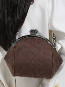 Brown suede shell bag with diamond stitching and metal chain strap on model