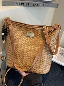 Brown woven bucket bag with gold clasp and wooden bead charm for fashion women