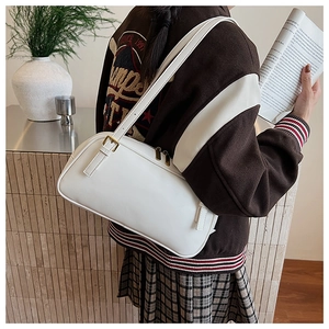 Detail of white leather baguette bag with vintage gold metal buckle on a shoulder strap