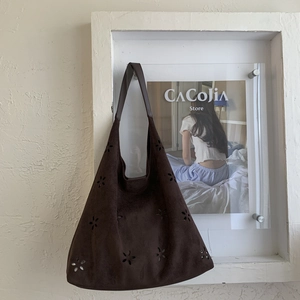 Detailed laser-cut floral pattern on a dark brown suede tote bag for women