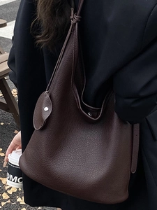 Minimalist dark brown litchi grain leather bucket bag with knotted shoulder strap