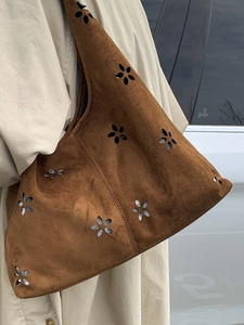 Brown suede hobo shoulder bag featuring floral cutout patterns and spacious college style