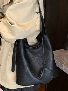 Minimalist black lychee leather bucket bag with top handle and round base for women