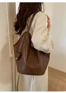Détail du grand sac cabas vintage marron avec texture cuir brillante et boucle dorée
