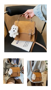 Detail of tan square crossbody bag with quilted flap, metal buckles and plush puppy charm