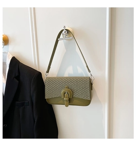 Detail showing woven texture flap and smooth olive green leather finish on the crossbody bag