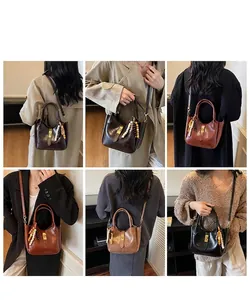 Detailed views of vintage bucket handbag featuring glossy finish and beaded pendant accessory
