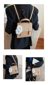 Detail view of beige quilted mini backpack with NINAITE logo and cute plush puppy charm