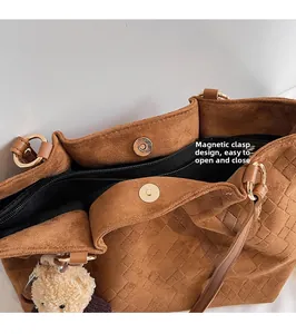 Close-up of brown suede tote bag with magnetic snap and woven embossed texture detail