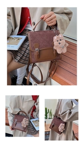Close-up of brown quilted faux suede handbag featuring vintage metal buckles and a bear charm