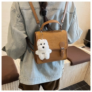 Brown quilted PU leather backpack on a model with a cute white puppy plush charm