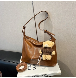 Detailed view of brown PU leather tote with a cute teddy bear charm and metal zipper