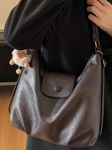Minimalist large brown hobo shoulder bag in soft faux leather with a cute plush pendant