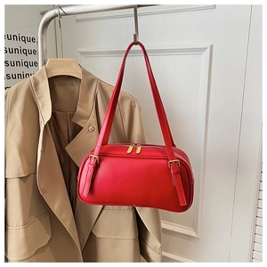 Detail view of a red matte leather shoulder bag with golden dual zippers and adjustable strap