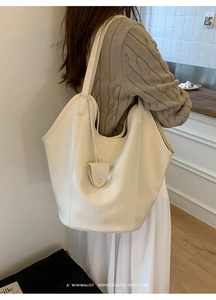Détail du grand sac seau crème minimaliste montrant sa capacité et sa petite pochette