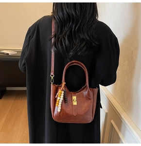 Detalle de un bolso tote de cuero marrón vintage con adorno de madera y cierre de hebilla metálica