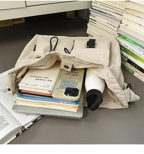 Detailed view of large capacity cream tote bag showing laptop and daily essentials
