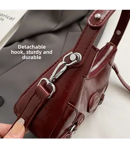 Macro detail of wine red embossed leather texture with durable silver metal hook attachment