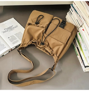 Close-up of brown drawstring bucket bag with buckle pockets and nylon texture details