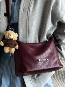 Retro burgundy leather tote bag with a cute bear charm and metallic brand plate detail