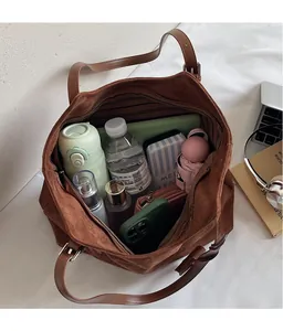 Vue intérieure d'un grand sac cabas en daim marron montrant sa capacité et son rangement