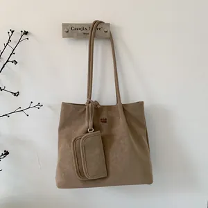 Close-up of minimalist khaki tote bag with PAN TOR logo and small matching pouch charm