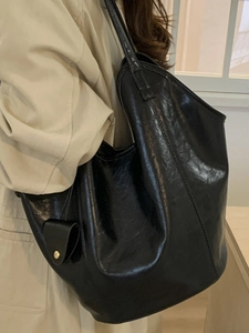 Grand sac cabas minimaliste en cuir noir avec bandoulière et pendentif doré élégant