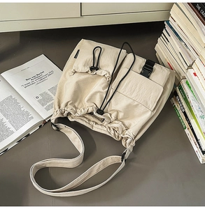 Detailed top view of a beige drawstring bucket bag with pockets in a lifestyle setting