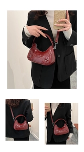 Detail showing high-gloss wine red patent leather finish and crescent moon bag silhouette