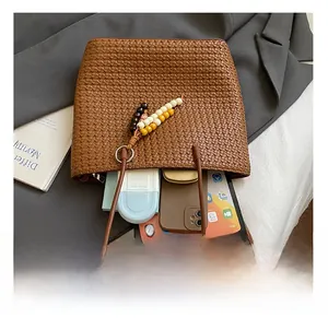 Detail showing high-capacity interior of brown woven tote bag with daily essentials