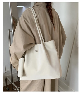 Detail view of the cream tote bag with PAN TOR logo and matching small hanging pouch