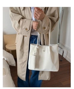 Detail of minimalist cream white tote bag with matching mini coin purse and shoulder strap