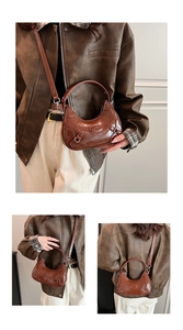 Detail of vintage brown leather crescent bag with brand embossing and adjustable strap