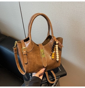 Detalle de bolso marrón vintage con cierre de metal dorado y adorno de cuentas