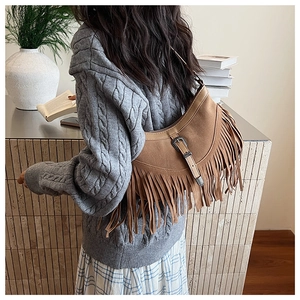Détail du sac bandoulière marron en daim avec franges et boucle argentée vintage