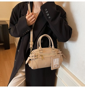 Beige faux leather shoulder bag featuring multi-zipper pockets and bear card holder detail