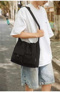 Close-up of black nylon drawstring bucket bag featuring a side buckle and brand label