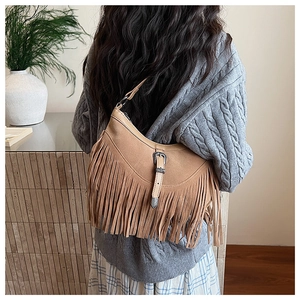 Détail d'un sac hobo en daim marron avec de longues franges et une boucle vintage