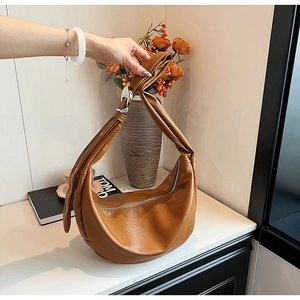 Detail der karamellbraunen Hobo-Tasche mit silberner Schnalle und Lederstruktur