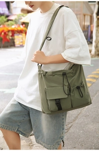 Detailed close-up of army green drawstring bucket bag with buckle pocket and nylon texture