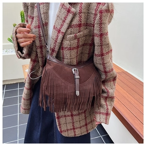 Détail du sac bandoulière en daim marron avec franges rétro et boucle en métal vintage