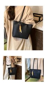 Detail view of black woven tote bag with colorful beaded tassel and fine double straps