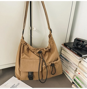 Detailed close-up of a large capacity khaki nylon bucket bag with functional drawstring pockets