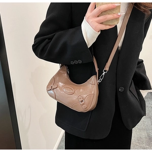 Detail of khaki brown crescent bag with glossy crinkled leather and metallic buckle straps