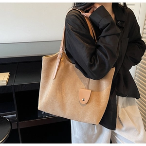 Détail du grand sac cabas en daim mat avec poignées en cuir et boucles de réglage en métal