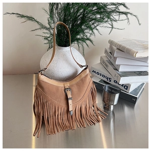 Détail du sac bohème marron en daim à franges avec boucle rétro sur un support élégant