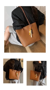 Detail of a brown woven PU leather tote bag with a colorful beaded charm accessory